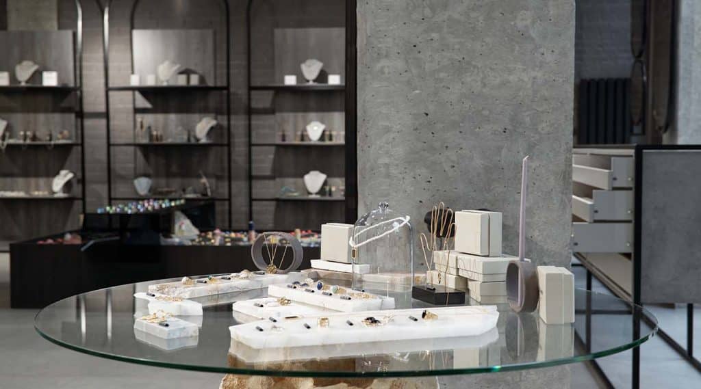 Table with assortment of jewelry items such as earrings, rings, chains and necklaces in contemporary luxurious boutique